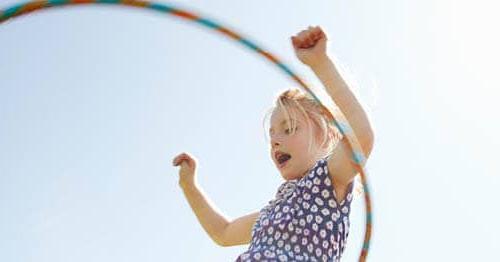 A child is outside hula hooping